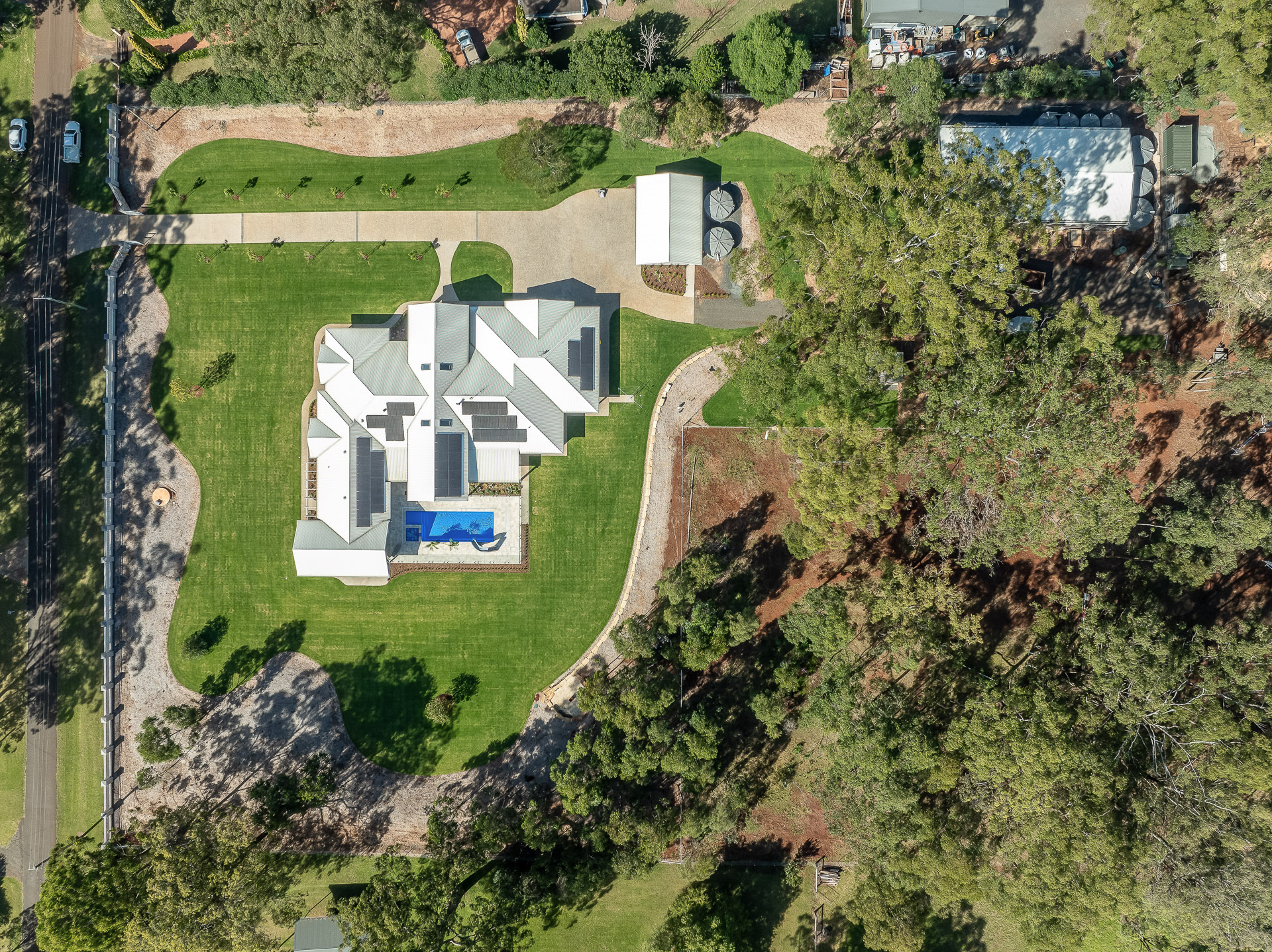 A modern house with a white roof is sitting on top of a lush green lawn. — Windamere Homes in Highfields, QLD